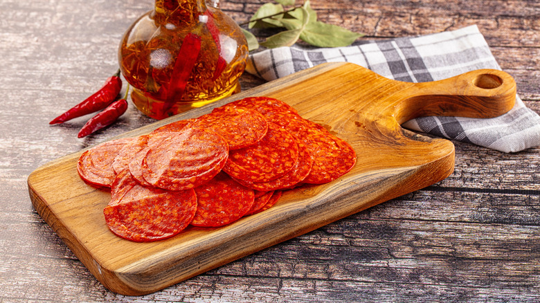 Sliced pepperoni on a chopping board