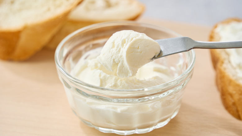 Cream cheese scooped up from a small bowl