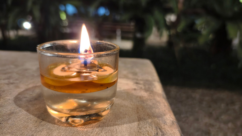 A small oil lamp burning on a table