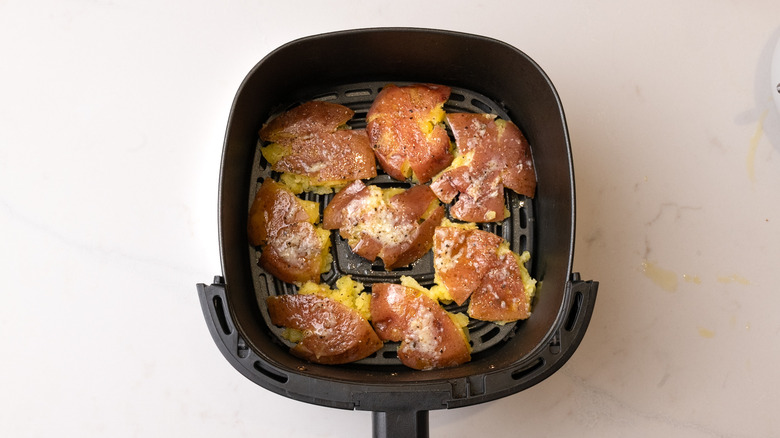 not yet air-fried smashed potatoes in air fryer basket