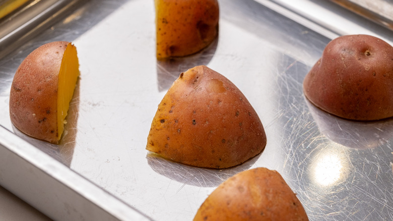 chopped boiled red potatoes spaced out on a flat tray