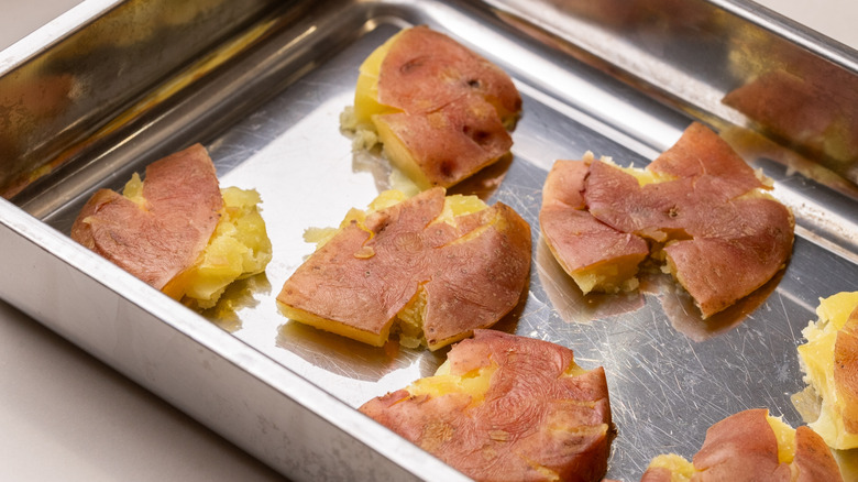 close up of smashed red potatoes in a tray