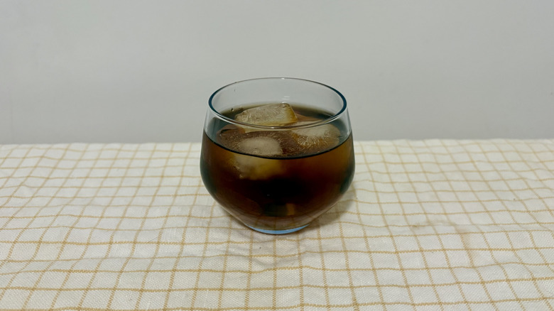 Coca-Cola and apple juice in short glass with ice