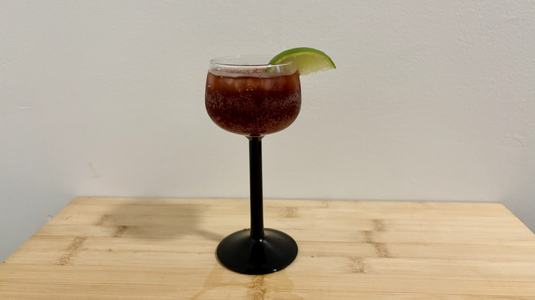 Coca-Cola and grenadine in stem glass with lime