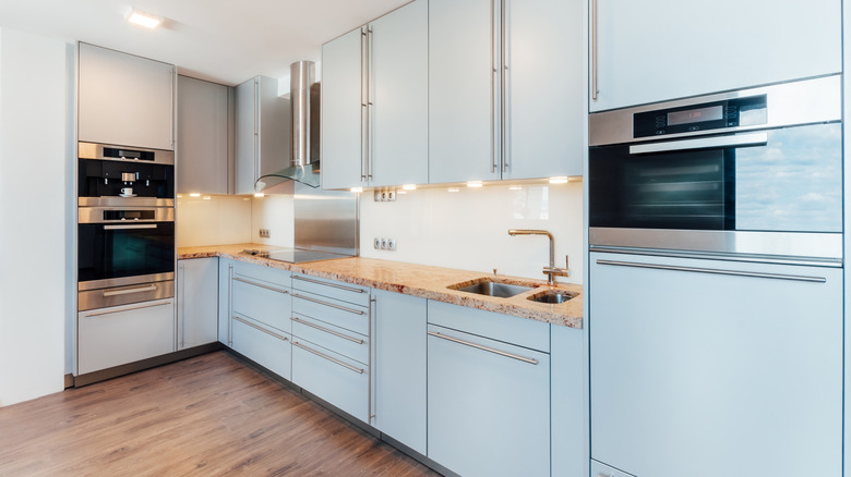 A kitchen has cabinets that are all light blue.