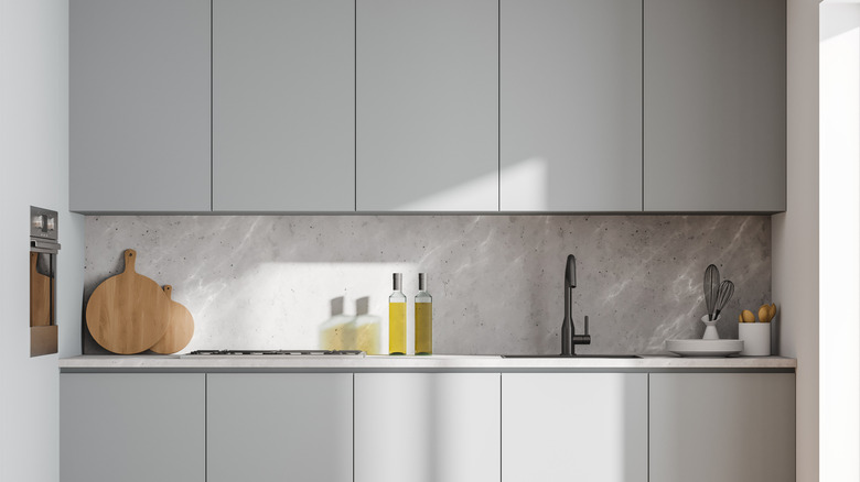 A small kitchen has light gray cabinetry.