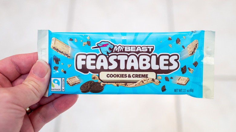 Person's hand holding a Mr Beast Feastables chocolate bar