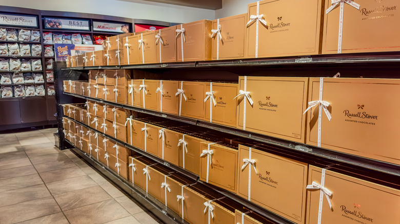 Russel Stover chocolate store with rows of gold boxes of assorted chocolates