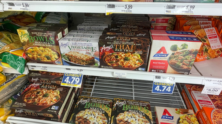 Frozen meals from several brands lining grocery store freezer shelves