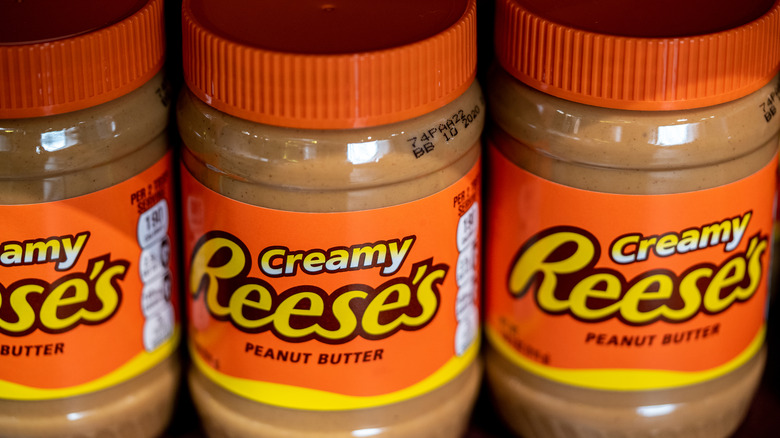 Three plastic containers of Reese's creamy peanut butter spread