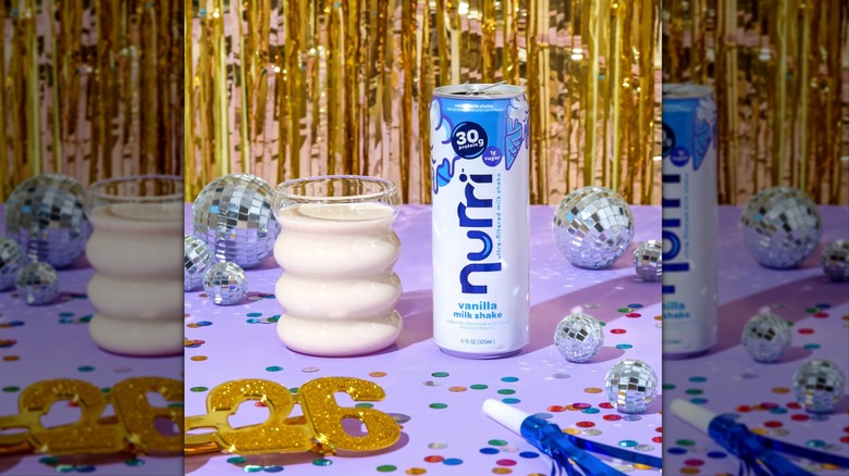 Nurri can and in glass surrounded by decor on purple surface