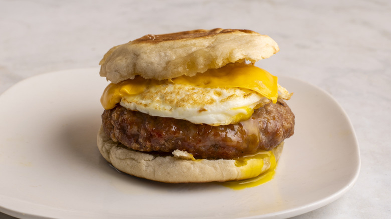 Sausage, egg and cheese breakfast sandwich on a white plate
