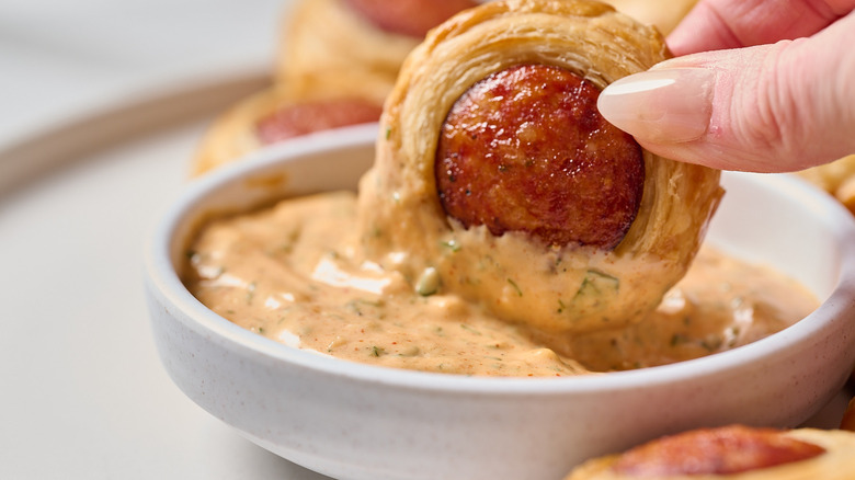 Dipping puff pastry bite into remoulade