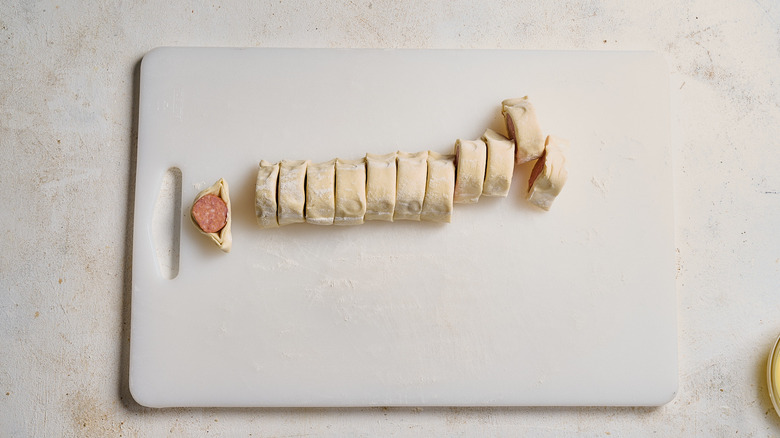 slicing andouille sausage inside of puff pastry