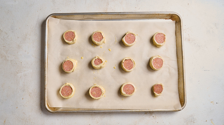 Sausage puff pastry pieces on a sheet tray