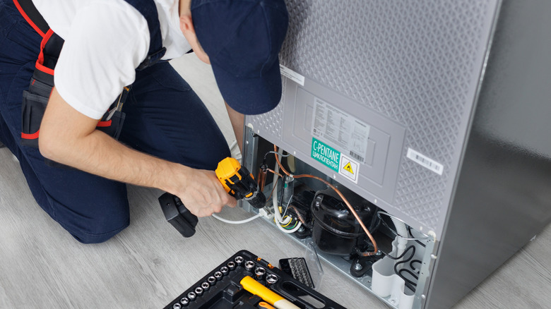 Technician repairing an appliance back