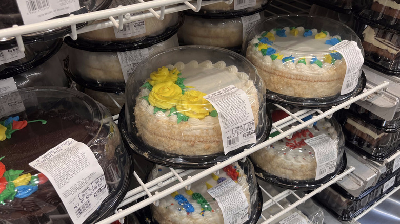 Decorated chocolate and white cakes with flower designs on display in Costco store