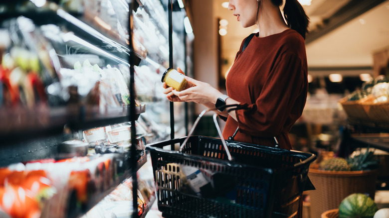 Woman reading food packaging at grocery store