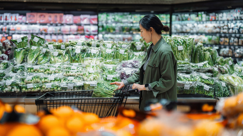 Young woman shops through produce section