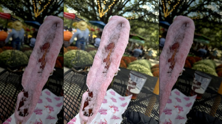 Bacon cotton candy on a stick, with cafe in background, mirrored image