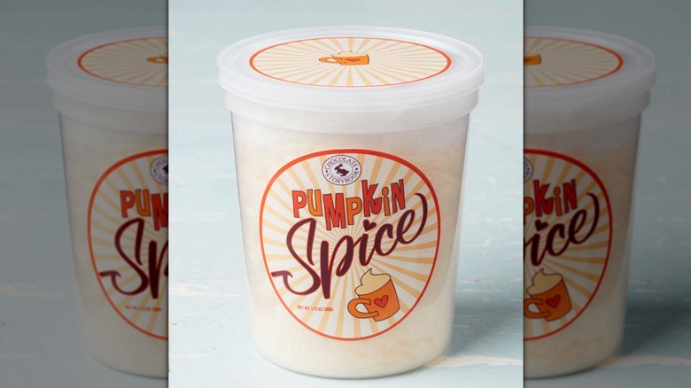 tub of pumpkin spice cotton candy on blue background, mirrored image