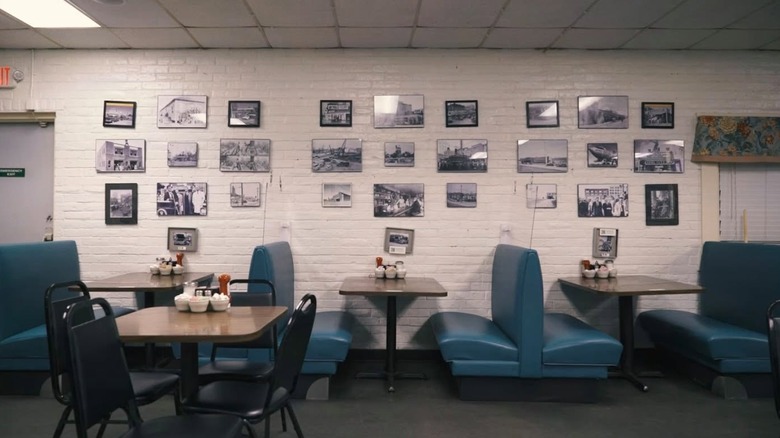 Inside of a restaurant with pictures on a white wall