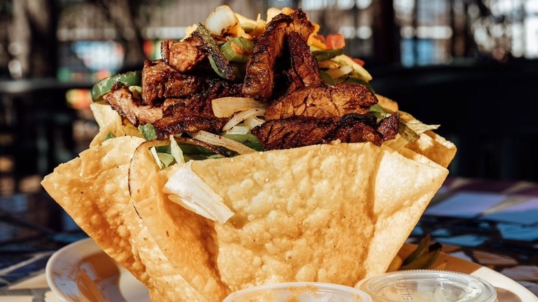 taco salad served in a crisp, fried tortilla bowl