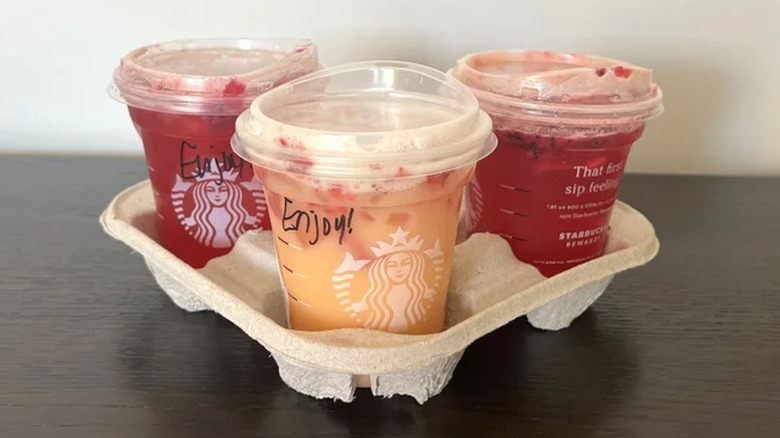 Three Starbucks Mango Strawberry Refresher drinks in a carrier