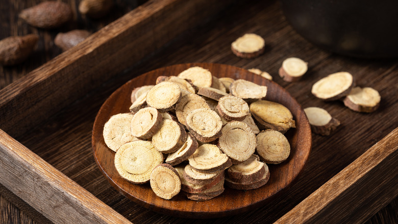 slices of dried licorice root on wooden plate
