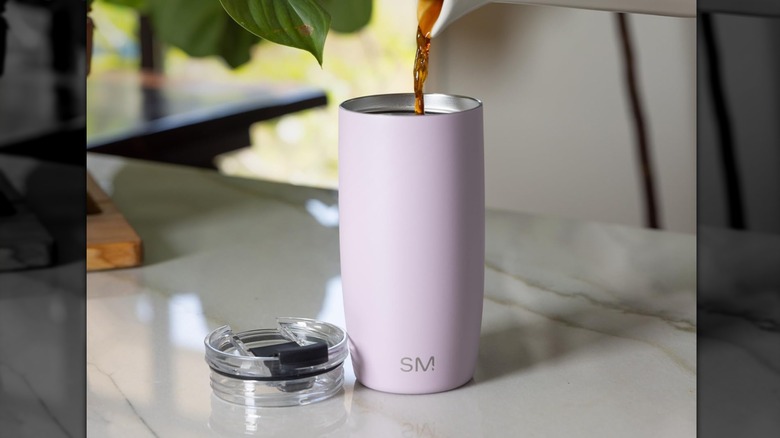 Coffee is poured into the Simple Modern Voyager Travel Coffee Mug resting on a countertop