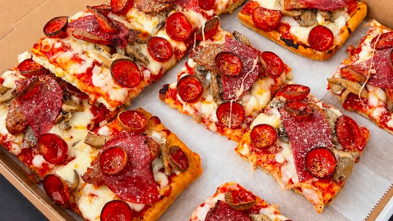 Square pieces of pepperoni pizza in box