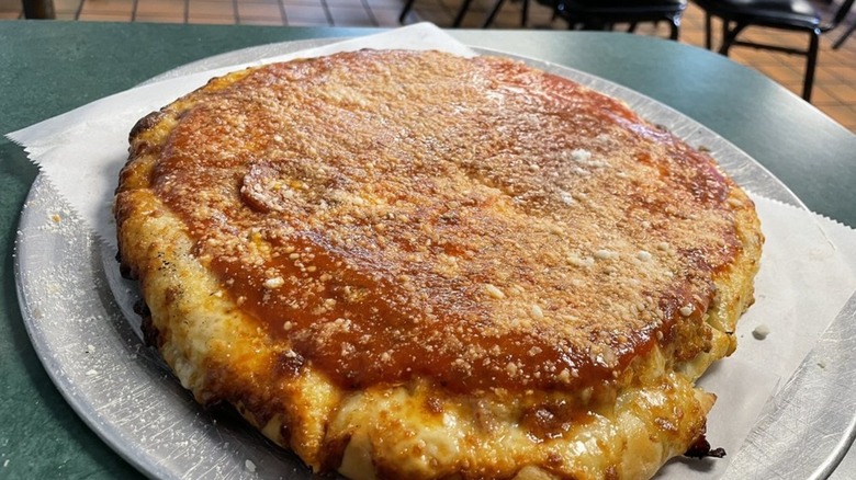 Upside-down pizza on silver tray on diner table