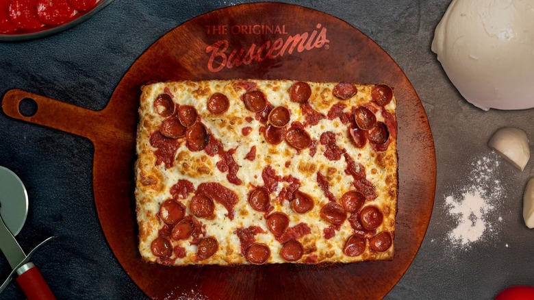 Rectangular pepperoni pizza on board reading The Original Buscemi's