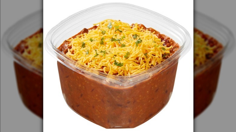 Kirkland Signature Beef Chili topped with cheese in a plastic deli container on a white background