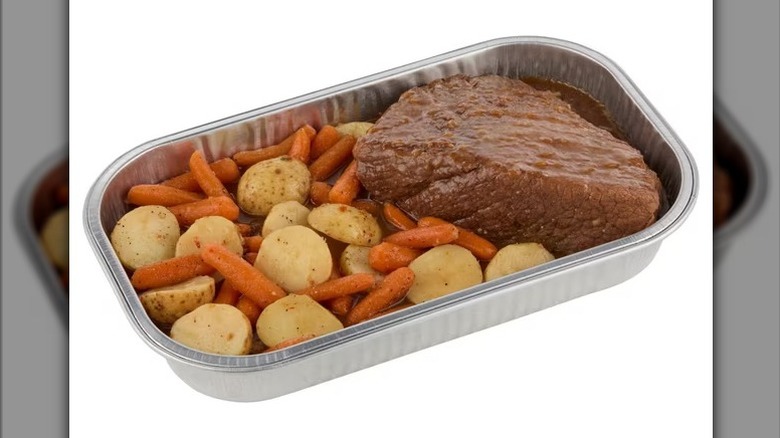 Member's Mark Beef Pot Roast with Carrots and Potatoes in an aluminum deli tin on a white background