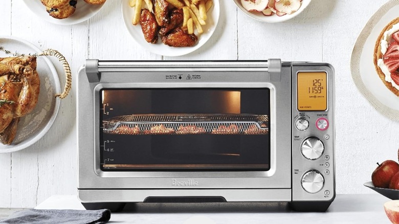 Breville Smart Oven Air Fryer Pro and Convection Oven with plates of food on background