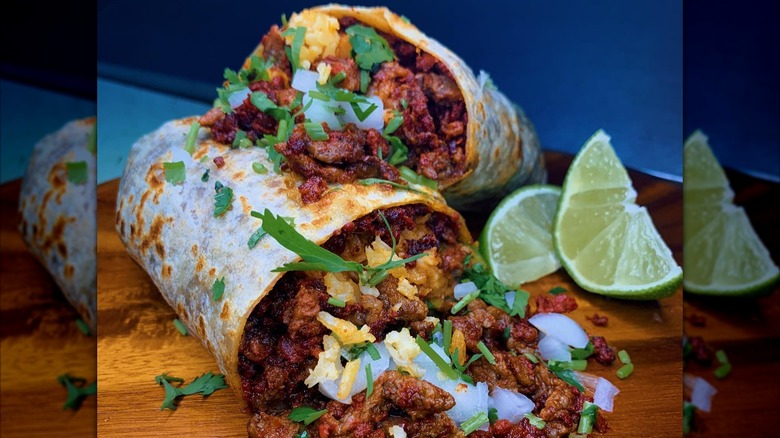 Burrito cut in half with steak, onion, and lime slices