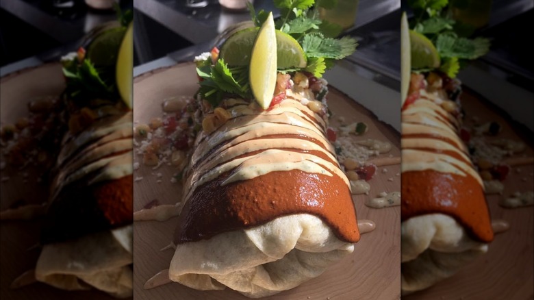 Smothered burrito with crema and lime slices