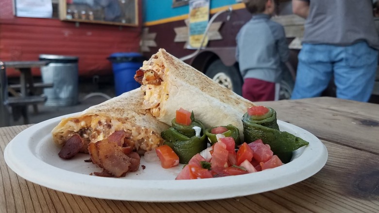 Breakfast burrito cut in half on a plate