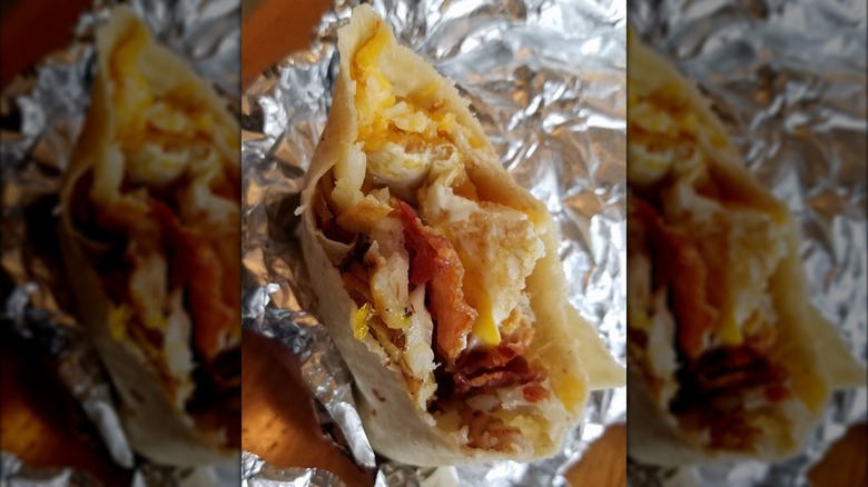 Half-eaten burrito on foil