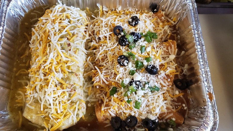 Smothered burritos with cheese in foil tray