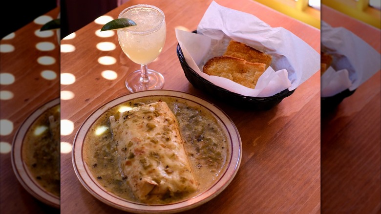 Burrito with green chile sauce and cocktail