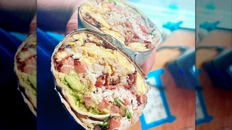 Two halves of a breakfast burrito with egg and avocado