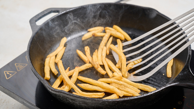 tossing french fries in a skillet