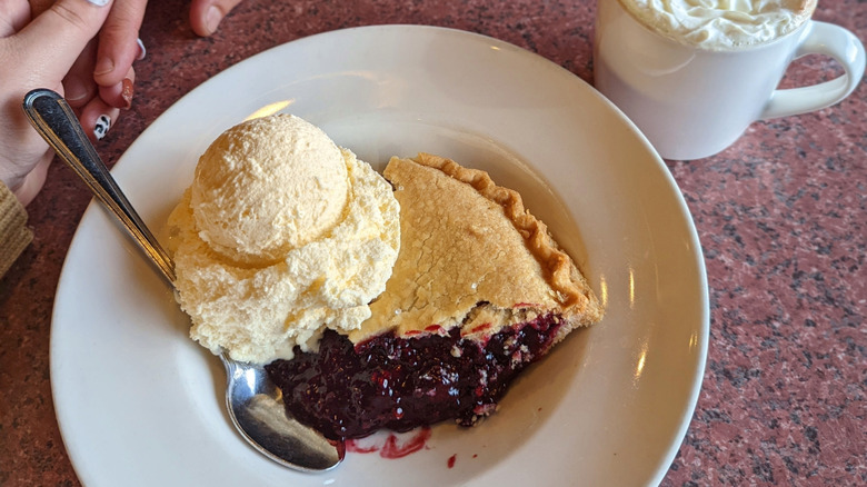 Marionberry pie slice topped with vanilla ice cream