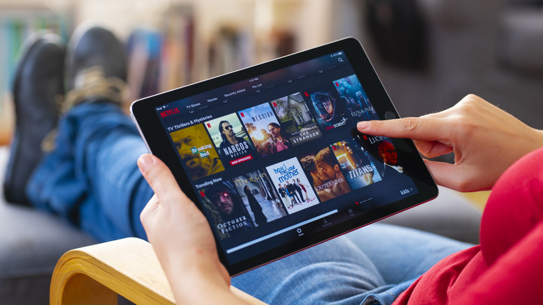 Person navigating Netflix on tablet