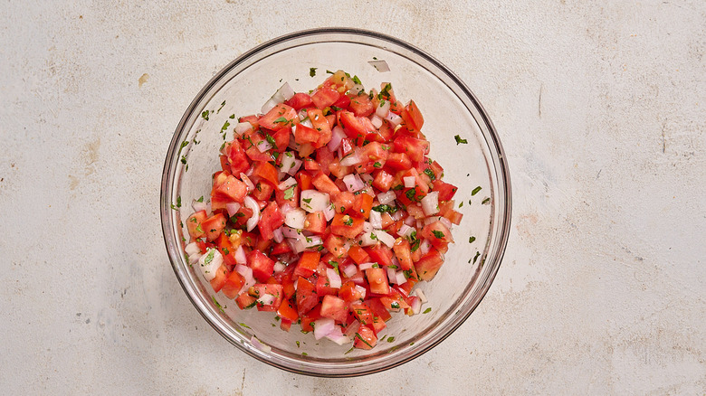 combining pico de gallo in a bowl
