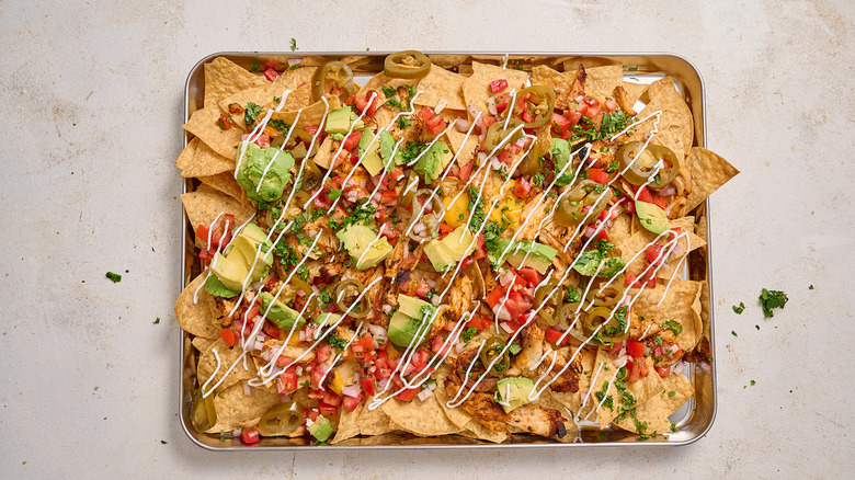 nachos on a sheet tray on a table