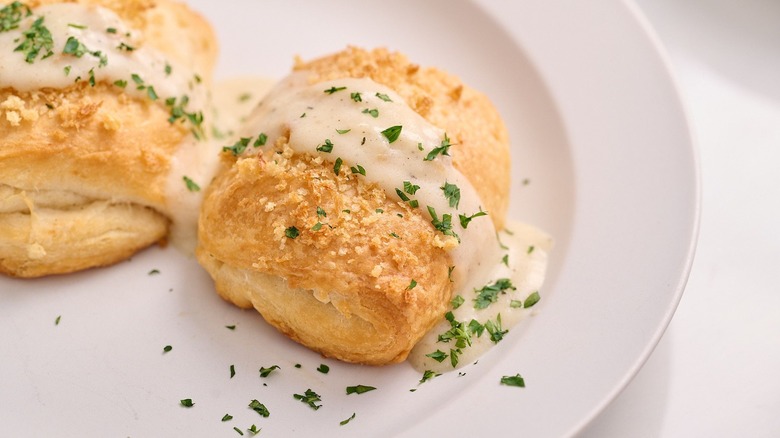 Croissant chicken pillows on plate topped with cream sauce