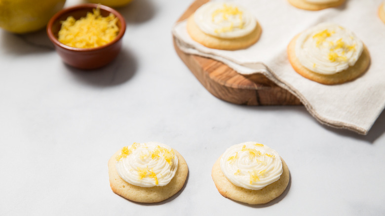 lemonade cookies on cloth and table next to dish of lemon zest